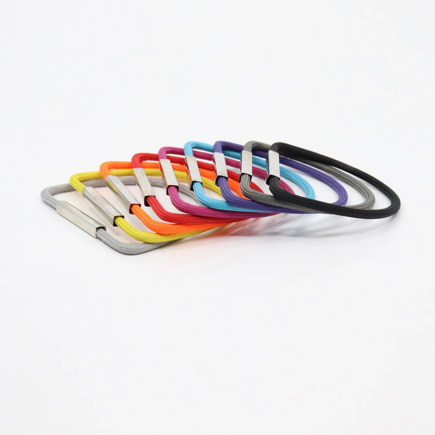 Set of colorful rectangular cord bracelets with silver clasps arranged in a fan shape on white background