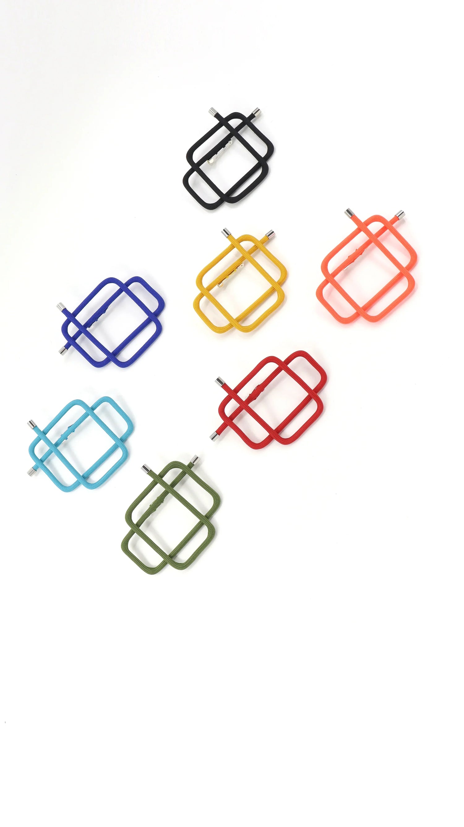 Colorful modular square jewelry pins in black, yellow, orange, blue, red, turquoise, and green on white background
