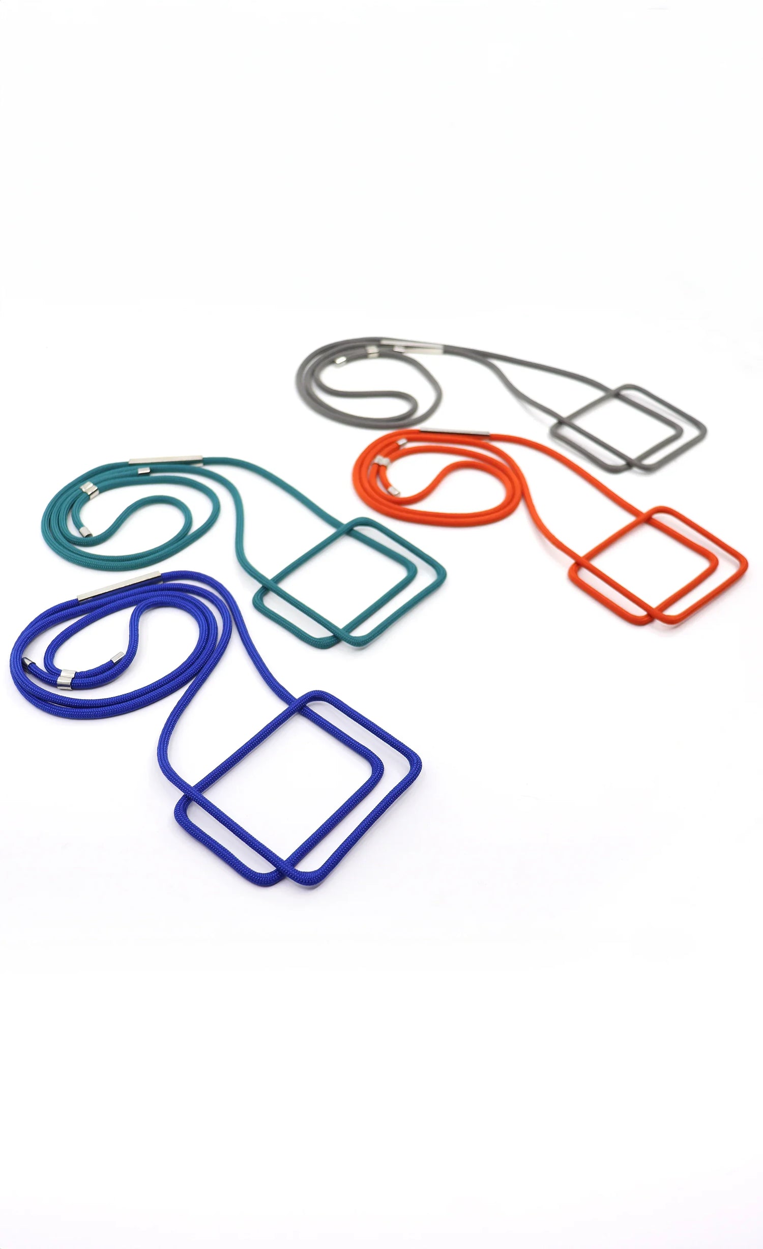 Colorful Linea collection modular necklaces with square pendants in blue, teal, orange, and gray on white