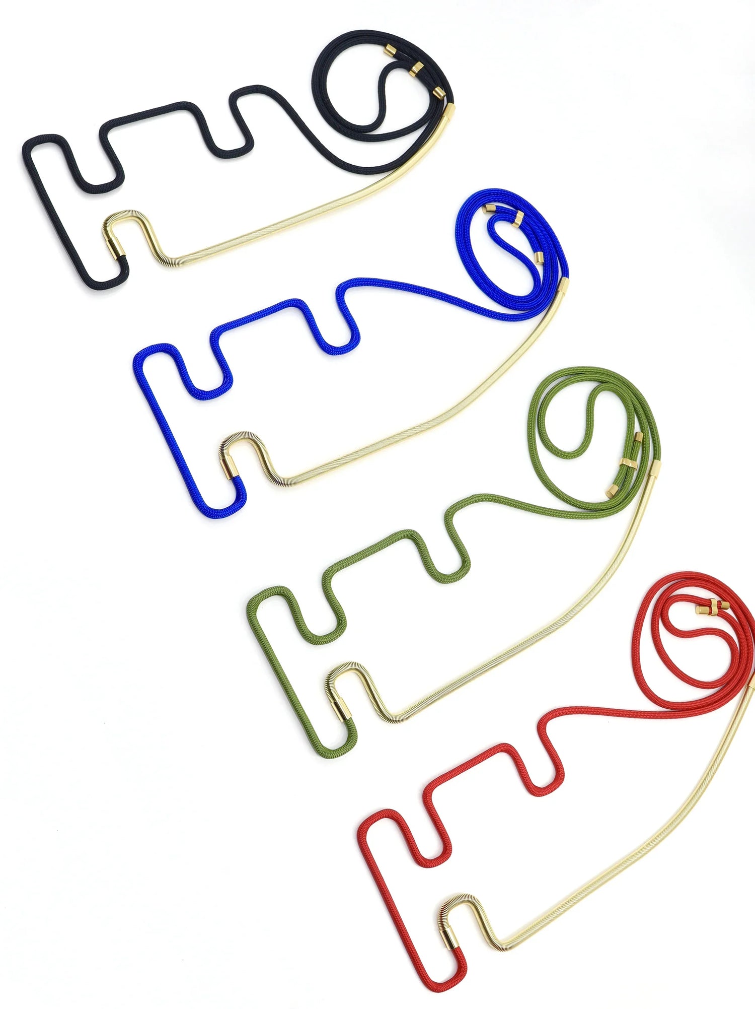 Colorful modular Linea collection necklaces in black, blue, green, and red with gold accents on white background