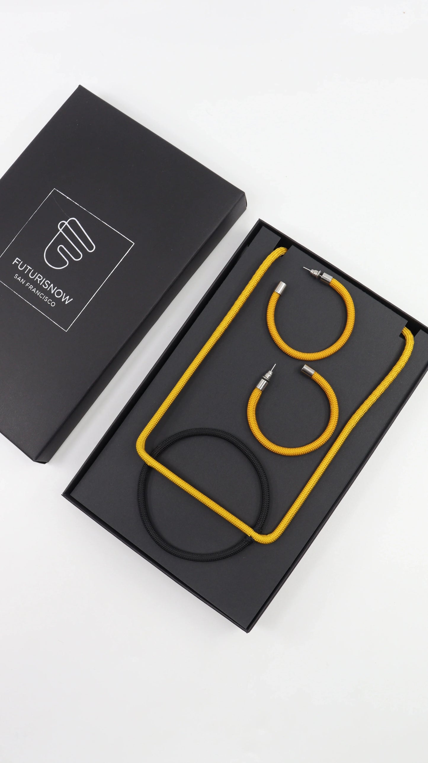 FuturisNow jewelry set in black box featuring yellow and black modular necklace and earrings with metal accents