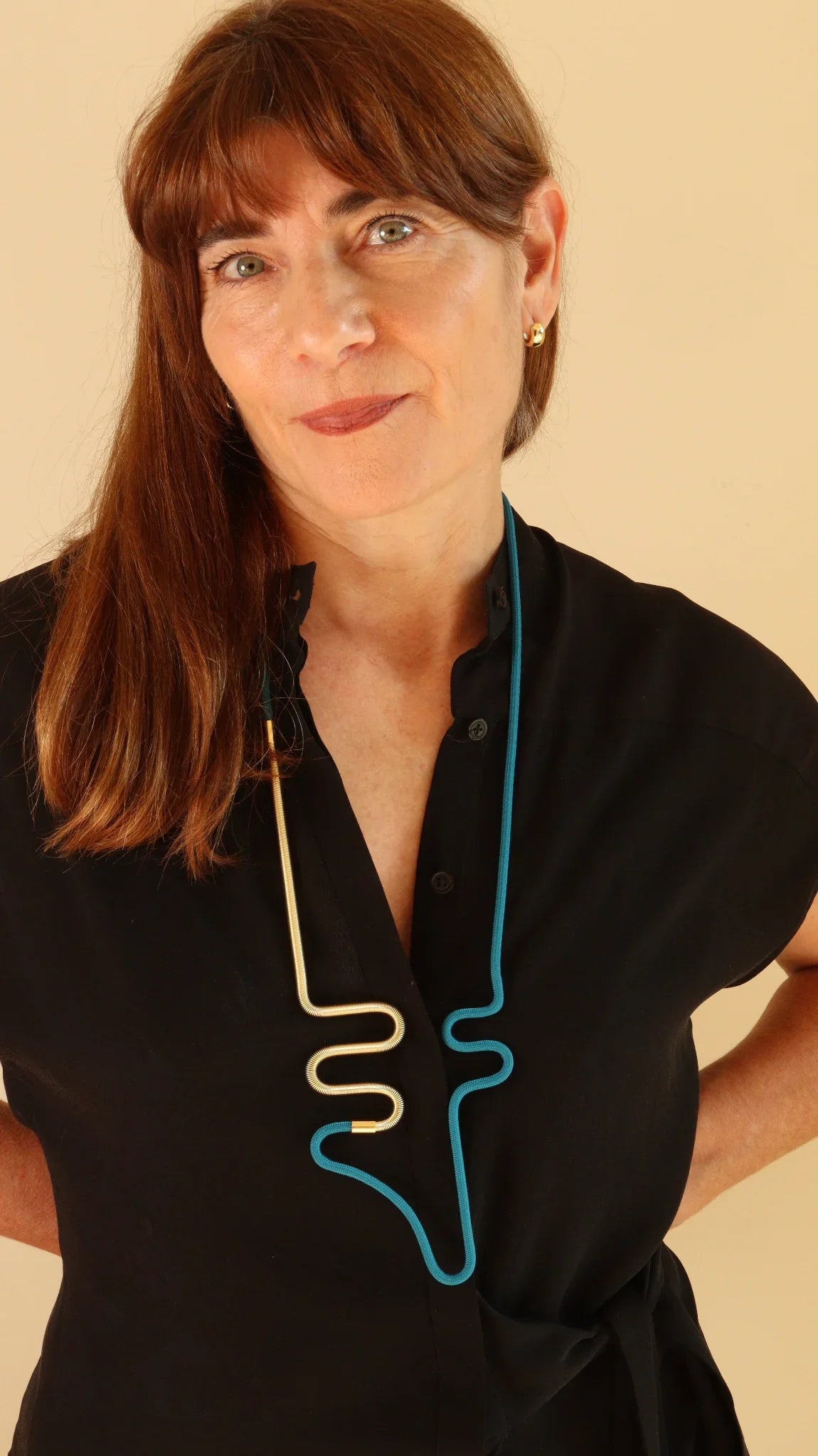 Woman wearing a black dress with blue and gold Futurisnow Necklace